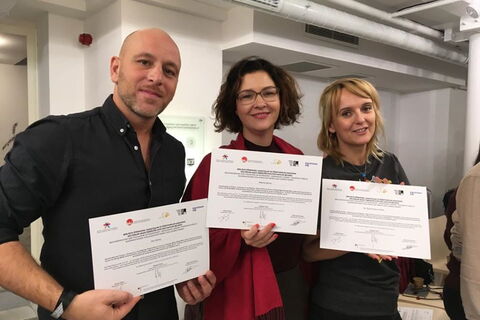 3 Menschen halten ihre Bescheinigung vor sich